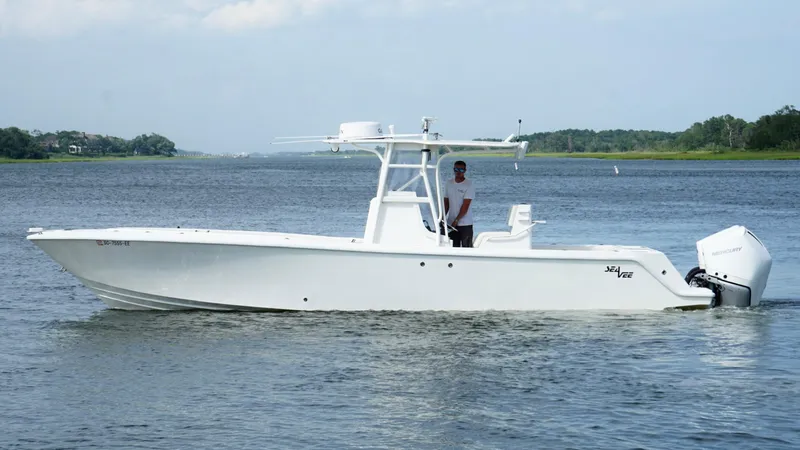  Yacht Photos Pics 2004 SeaVee 310B boat on calm water, featuring a sleek white design and center console.