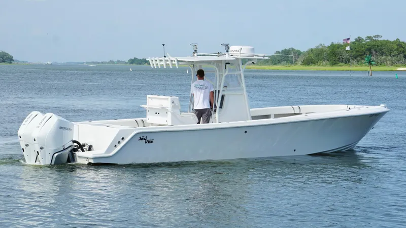  Yacht Photos Pics 2004 SeaVee 310B boat cruising on a calm river with lush green shoreline.