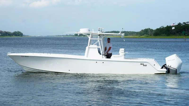  Yacht Photos Pics 2004 SeaVee 310B boat on calm water, side view, with a person at the helm.