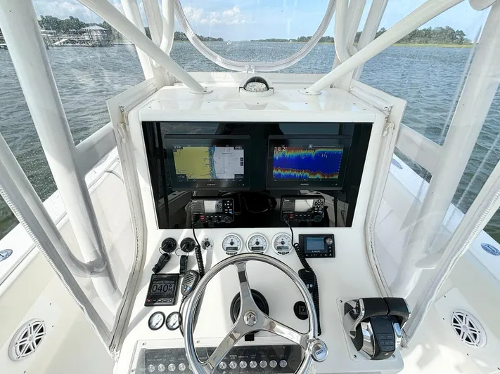  Yacht Photos Pics 2004 SeaVee 310B boat cockpit with navigation screens and steering wheel on open water.