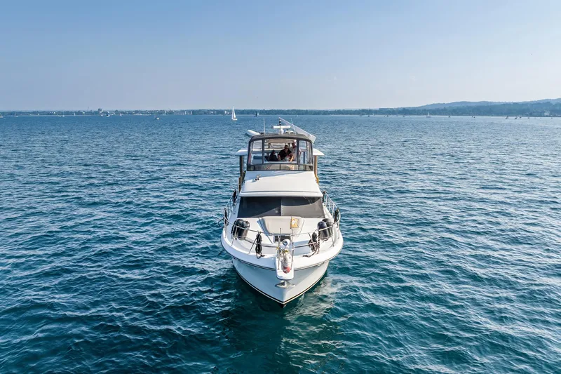 Perfectseas Yacht Photos Pics 1988 Carver 42 Aft Cabin Motoryacht cruising on a serene blue lake.