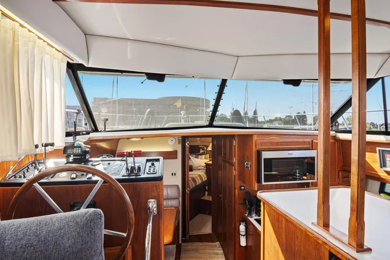 Perfectseas Yacht Photos Pics Interior of 1988 Carver 42 Aft Cabin Motoryacht with helm, microwave, and wood finishes.