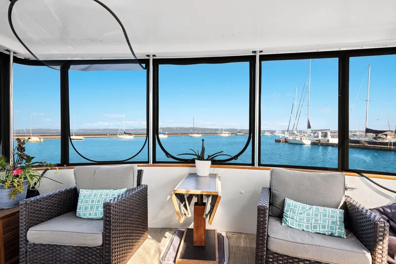 Perfectseas Yacht Photos Pics 1988 Carver 42 Aft Cabin Motoryacht interior with marina view, featuring cozy seating and decor.