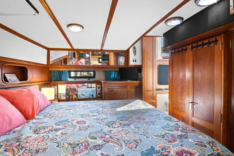Perfectseas Yacht Photos Pics 1988 Carver 42 Aft Cabin Motoryacht bedroom with floral bedding and wooden cabinetry.