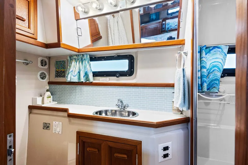 Perfectseas Yacht Photos Pics 1988 Carver 42 Aft Cabin Motoryacht bathroom with sink, mirror, and nautical decor.