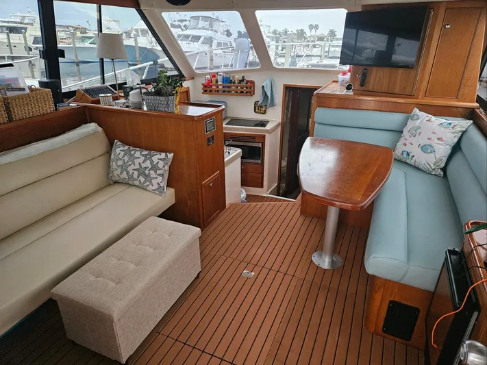  Yacht Photos Pics Interior of 1999 Riviera 40AC yacht with cozy seating and wooden flooring.