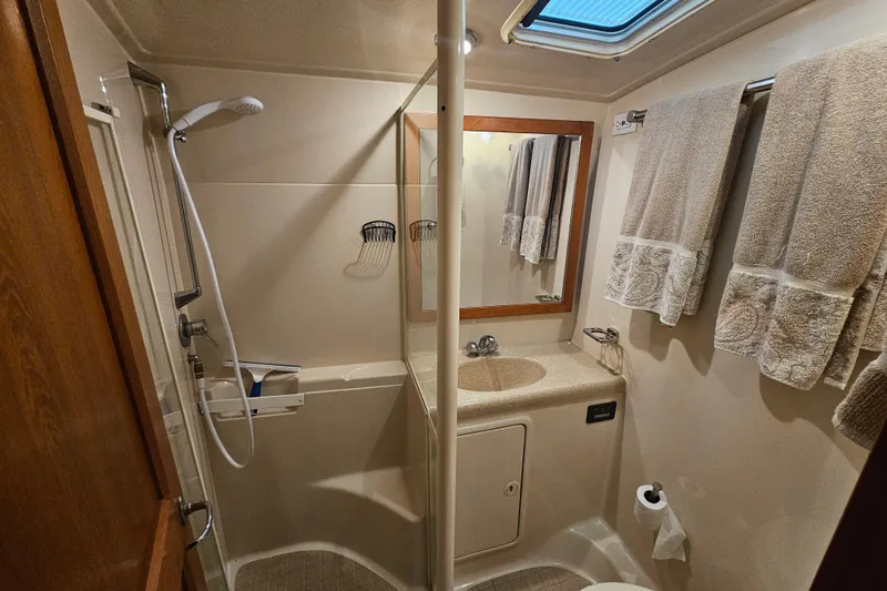  Yacht Photos Pics 1999 Riviera 40AC yacht bathroom with shower, sink, and towels.