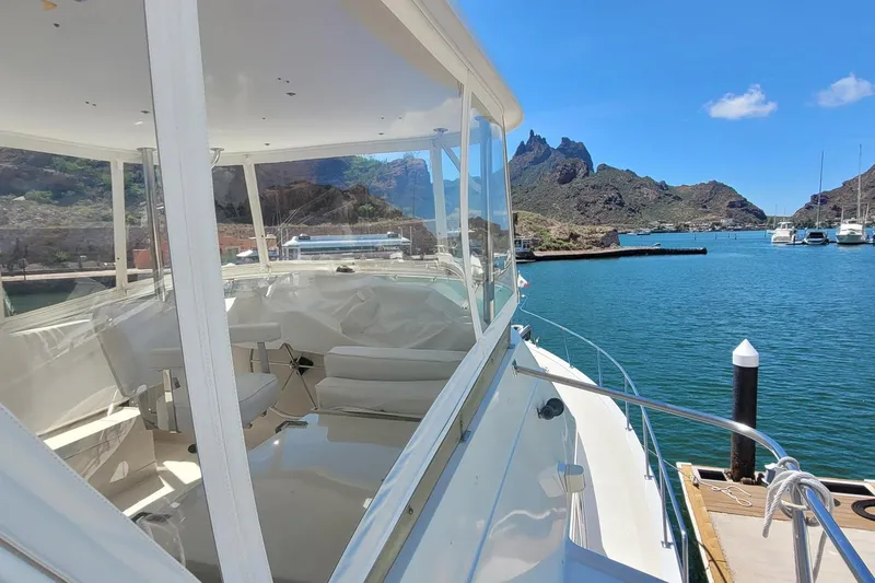 The Wetbar Yacht Photos Pics 1989 Offshore Yachts 48 Sedan docked in scenic marina with mountainous backdrop.