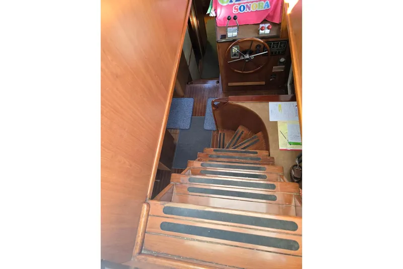 The Wetbar Yacht Photos Pics Interior view of 1989 Offshore Yachts 48 Sedan, featuring wooden stairs and helm station.
