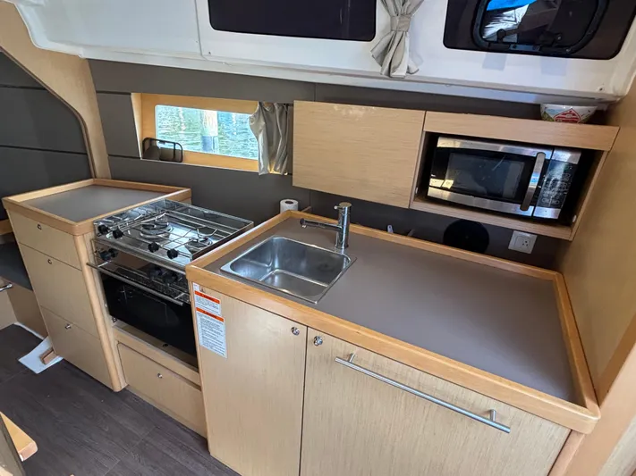 Rio Babe Yacht Photos Pics Modern kitchen in 2015 Beneteau Oceanis 35 yacht with stove, sink, and microwave.