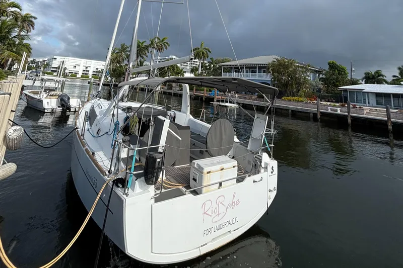 Rio Babe Yacht Photos Pics 2015 Beneteau Oceanis 35 docked in a marina, surrounded by palm trees.