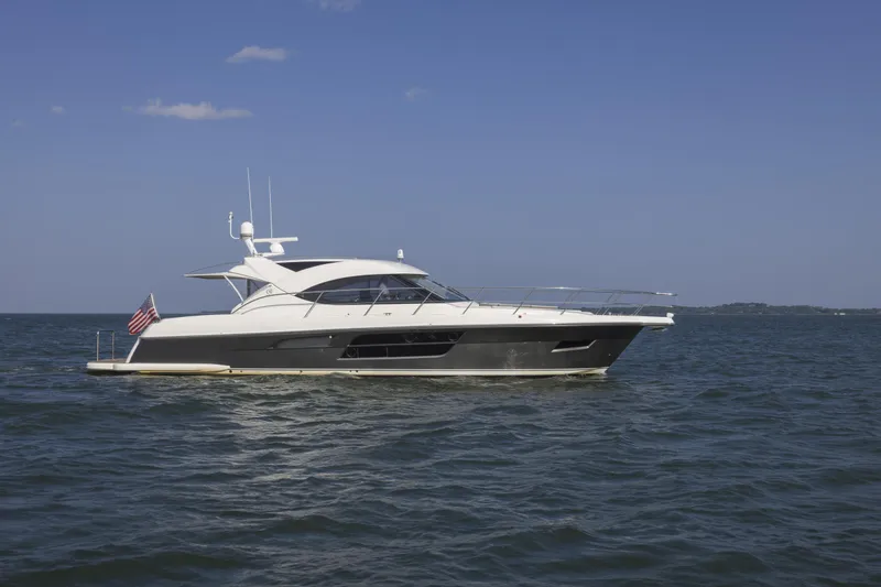 Pronto Yacht Photos Pics 2016 Riviera 5000 Sport Yacht cruising on open water under clear blue sky.