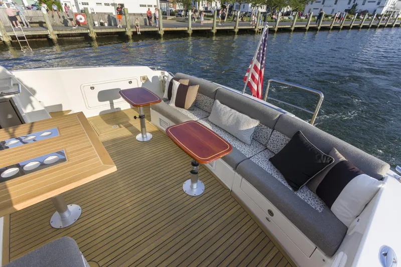 Pronto Yacht Photos Pics Luxurious 2016 Riviera 5000 Sport Yacht deck with seating, tables, and American flag.