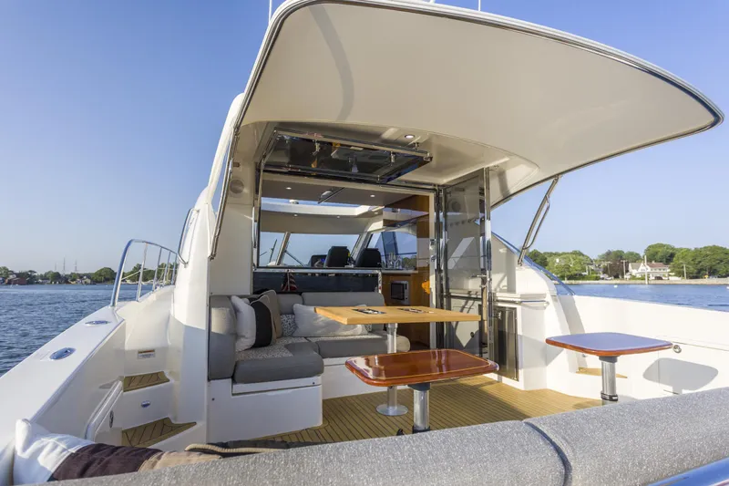 Pronto Yacht Photos Pics 2016 Riviera 5000 Sport Yacht with spacious deck and luxurious seating on calm waters.