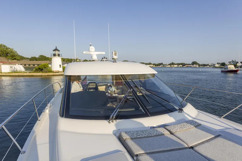Pronto Yacht Photos Pics 2016 Riviera 5000 Sport Yacht cruising near a lighthouse on a sunny day.