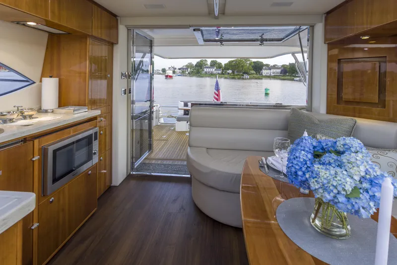 Pronto Yacht Photos Pics Luxurious interior of 2016 Riviera 5000 Sport Yacht with elegant dining area and scenic water view.