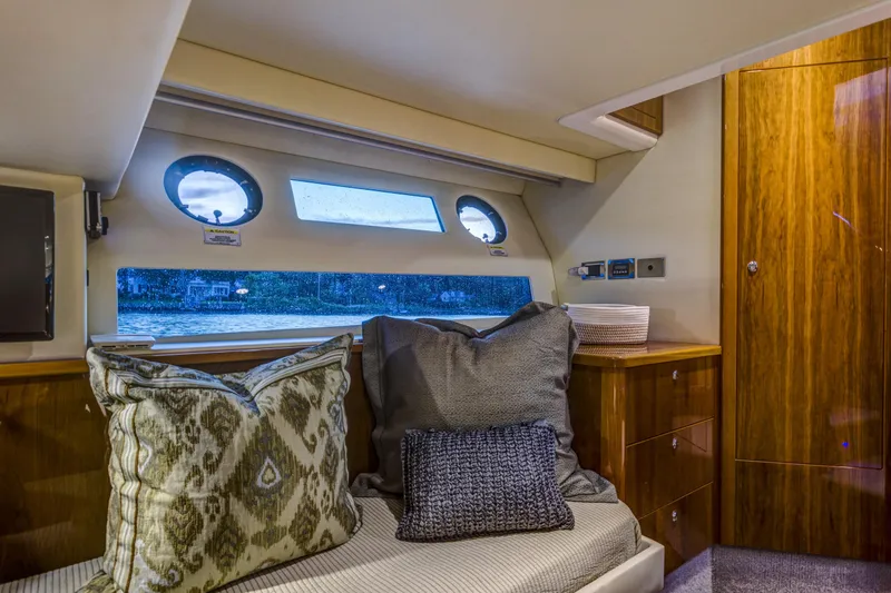 Pronto Yacht Photos Pics Luxurious interior of 2016 Riviera 5000 Sport Yacht with plush cushions and wooden cabinetry.