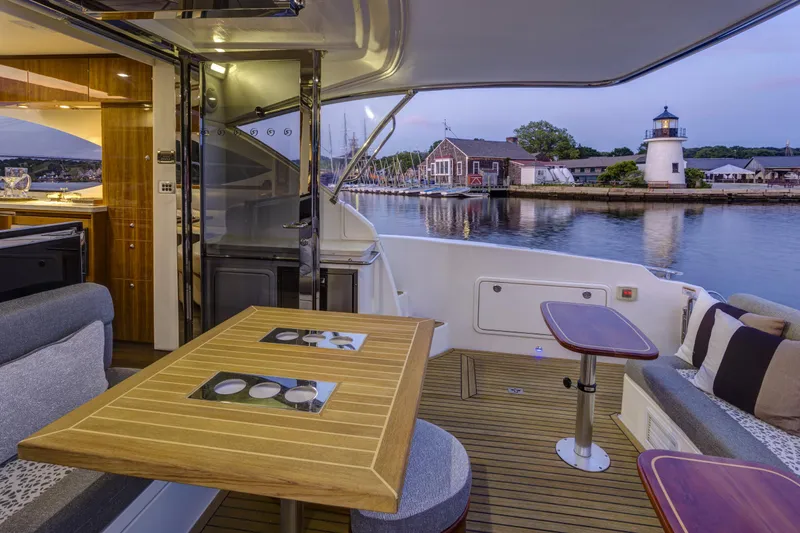 Pronto Yacht Photos Pics Luxurious 2016 Riviera 5000 Sport Yacht interior with waterfront view and lighthouse in background.