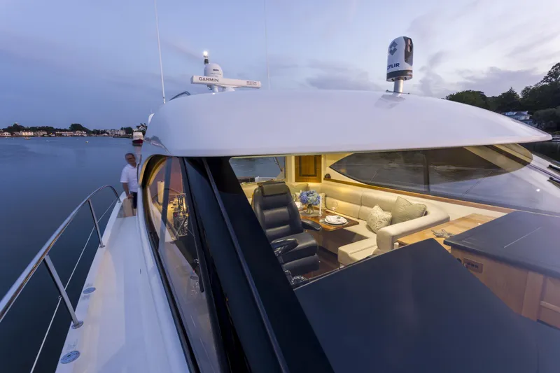 Pronto Yacht Photos Pics 2016 Riviera 5000 Sport Yacht on calm water at dusk, featuring luxurious interior seating.