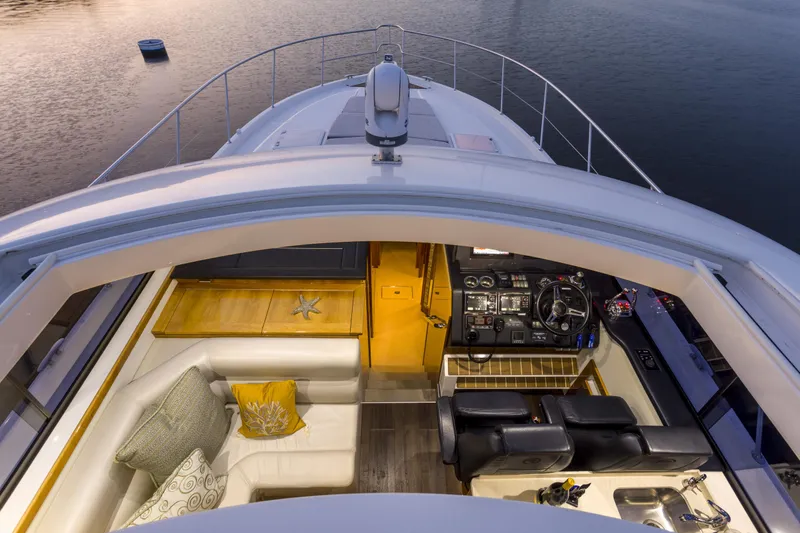 Pronto Yacht Photos Pics 2016 Riviera 5000 Sport Yacht interior with helm, seating, and elegant design at sunset.