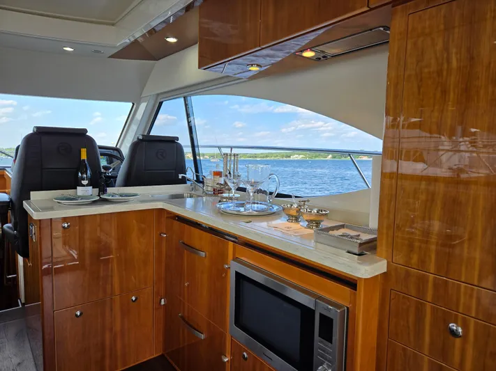 Pronto Yacht Photos Pics Luxurious interior of 2016 Riviera 5000 Sport Yacht with elegant wood finish and scenic ocean view.