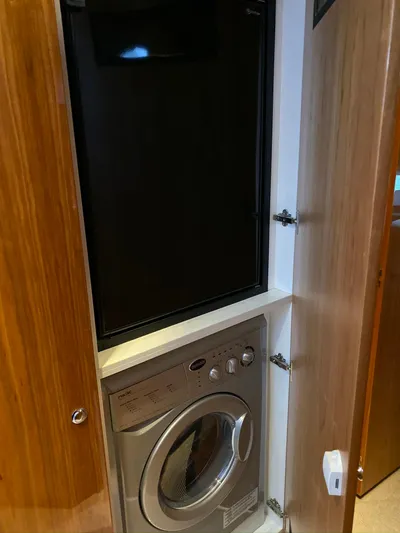 Pronto Yacht Photos Pics Laundry area with washer and dryer in 2016 Riviera 5000 Sport Yacht.