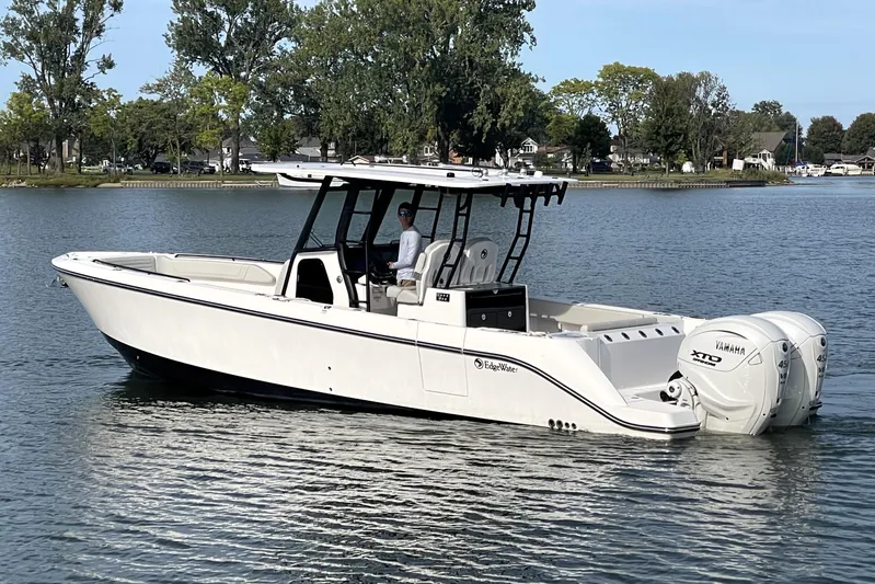  Yacht Photos Pics 2025 Edgewater 340CC boat on a calm lake with trees in the background.
