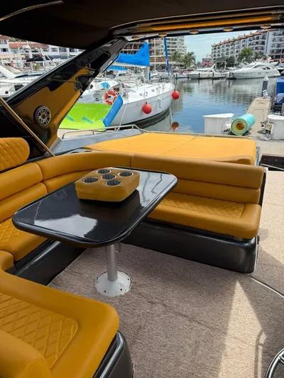  Yacht Photos Pics Sunseeker Predator 58 yacht interior with yellow seating, table, and marina view.