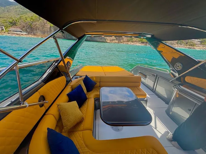  Yacht Photos Pics Luxurious Sunseeker Predator 58 yacht interior with yellow seating, blue cushions, and ocean view.
