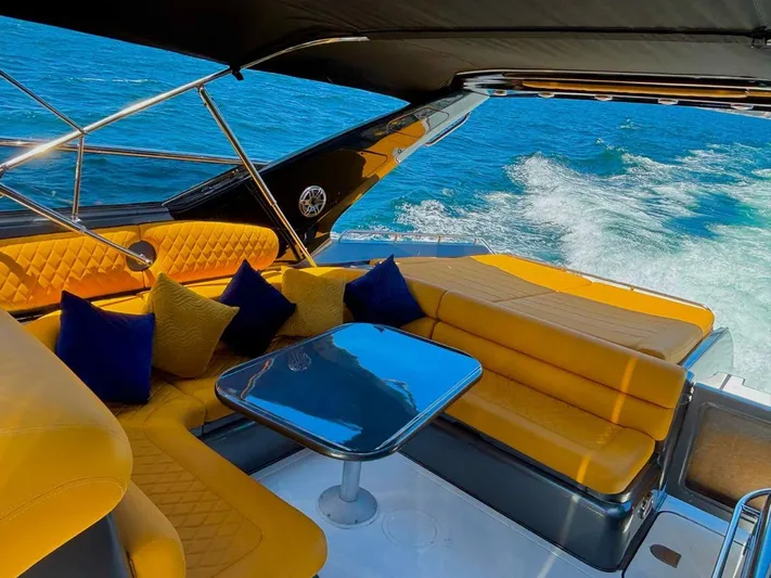  Yacht Photos Pics Luxurious Sunseeker Predator 58 yacht interior with yellow seating, blue cushions, and ocean view.