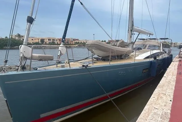 Hindsight Yacht Photos Pics 2016 Jeanneau 64 yacht docked by the waterfront, showcasing sleek design and blue hull.