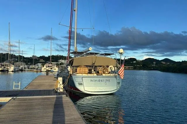 Hindsight Yacht Photos Pics 2016 Jeanneau 64 yacht docked at marina, calm waters, scenic background.