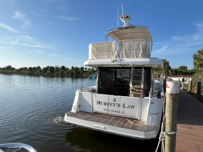 Murfey's Law Yacht Photos Pics 2020 Beneteau Swift Trawler 35 docked by a serene waterfront.