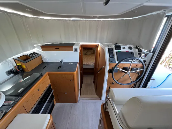 Murfey's Law Yacht Photos Pics Interior of 2020 Beneteau Swift Trawler 35, featuring helm, kitchen, and cabin entrance.