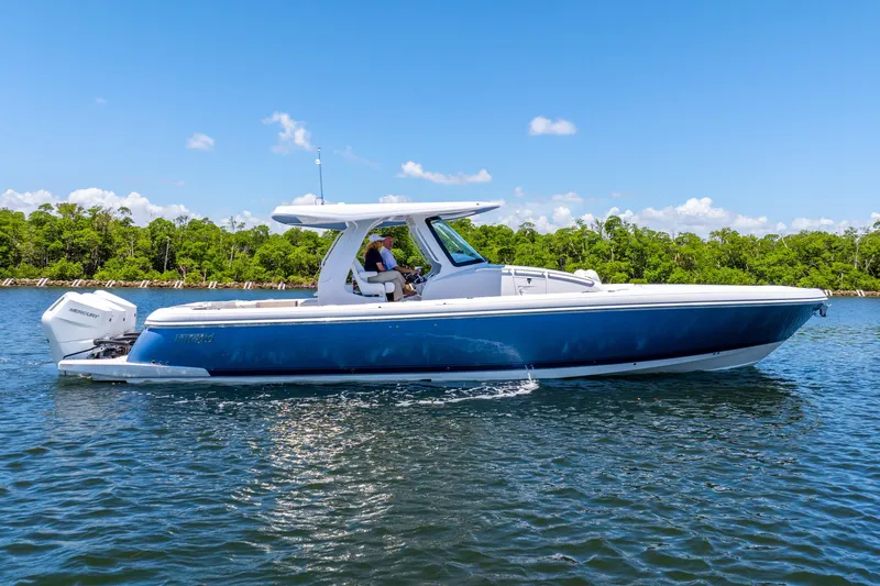  Yacht Photos Pics 2025 Intrepid 41 Panacea boat cruising on a sunny day, surrounded by lush greenery.