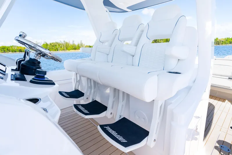  Yacht Photos Pics Luxury seating on 2025 Intrepid 41 Panacea boat, featuring sleek white design and modern controls.