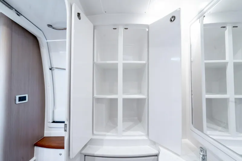  Yacht Photos Pics Open white cabinet with shelves inside the 2025 Intrepid 41 Panacea boat interior.
