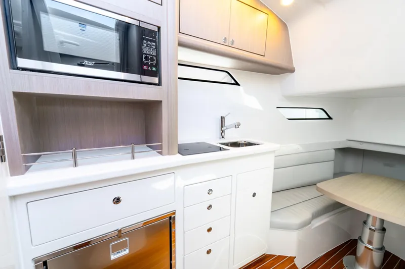  Yacht Photos Pics Modern kitchen interior of 2025 Intrepid 41 Panacea yacht with sleek cabinetry and seating.