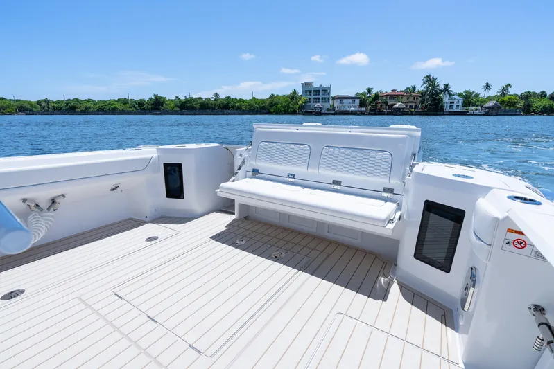  Yacht Photos Pics Luxurious 2025 Intrepid 41 Panacea boat deck with seating, overlooking serene waterfront homes.