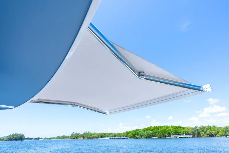  Yacht Photos Pics 2025 Intrepid 41 Panacea boat awning with scenic water and sky background.