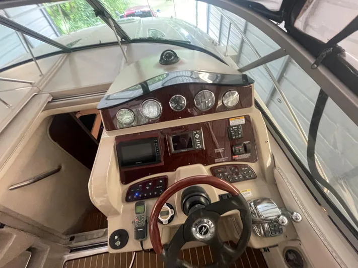 Andrew's Place Yacht Photos Pics 2009 Sea Ray 310 Sundancer helm with steering wheel, gauges, and navigation controls.