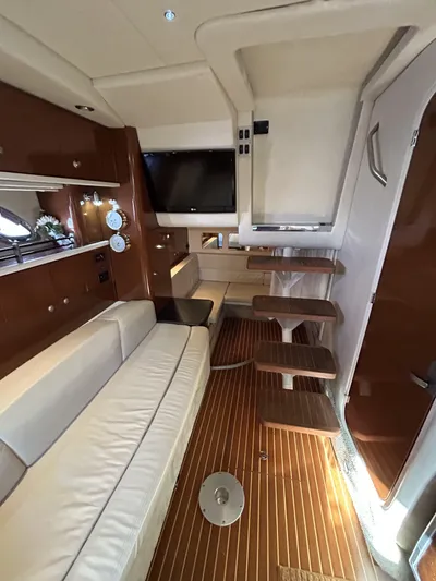 Andrew's Place Yacht Photos Pics Interior of 2009 Sea Ray 310 Sundancer yacht with wooden flooring and white leather seating.