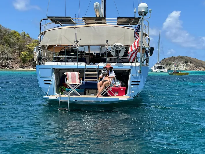 Hindsight Yacht Photos Pics 2016 Jeanneau 64 yacht anchored in tropical waters with people relaxing on the deck.