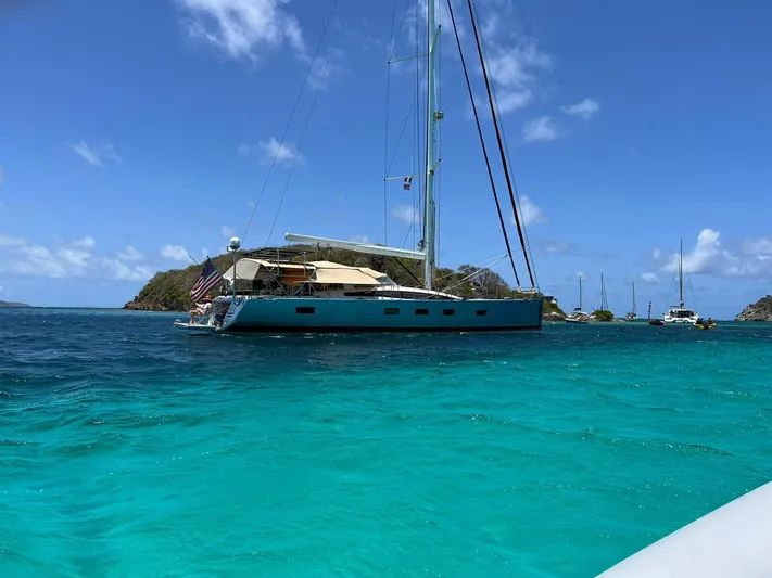 Hindsight Yacht Photos Pics 2016 Jeanneau 64 sailboat anchored in clear turquoise waters under a bright blue sky.