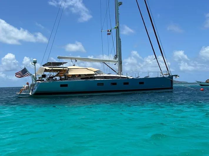 Hindsight Yacht Photos Pics 2016 Jeanneau 64 yacht anchored in clear turquoise waters under a bright blue sky.