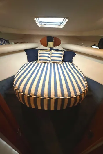 Tracy II Yacht Photos Pics Cozy cabin interior of 2002 Riviera 350 with striped bedding and overhead hatch.