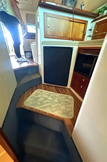 Tracy II Yacht Photos Pics Interior of a 2002 Riviera 350 yacht with wooden cabinetry and carpeted steps.