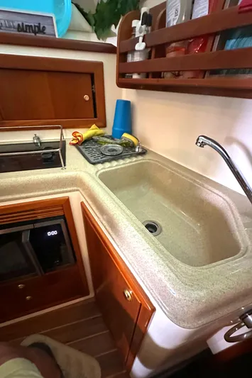 Tracy II Yacht Photos Pics 2002 Riviera 350 yacht kitchen with sink, stove, and wooden cabinetry.