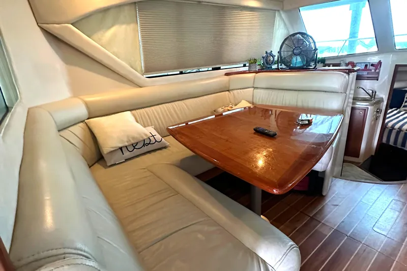 Tracy II Yacht Photos Pics Luxurious interior of a 2002 Riviera 350 yacht with leather seating and wooden table.