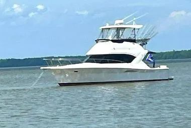 Tracy II Yacht Photos Pics 2003 Riviera 350 yacht cruising on a calm lake under a clear blue sky.
